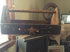 an old wooden box with a star on it sitting on top of a table next to a window