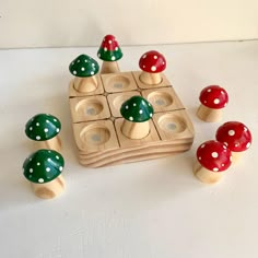 a wooden toy with red and green mushrooms on it's sides, surrounded by smaller ones