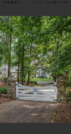 a gated driveway leading to a house in the woods