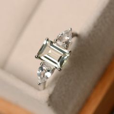 This ring features a 6*8mm emerald cut green amethyst and sterling silver finished with rhodium. Customization is available. It is made by hand, and it will take about 7 days to finish the ring after your payment is completed. Main stone: green amethyst Main stone weight: Approx 1.60 ct Metal type: sterling silver finished with rhodium Accent stone: CZ Customization is available, I also can make it with 14k solid gold (white or yellow or rose), just feel free to contact me. Any question, just le Luxury Green Multi-stone Amethyst Ring, Elegant Green Amethyst Ring In Sterling Silver, Classic Green Amethyst Rings, Silver Green Amethyst Ring In Fine Jewelry Style, Silver Fine Jewelry Amethyst Ring, Elegant Green Amethyst Ring With Accent Stones, Elegant Green Amethyst Topaz Gemstone Ring, Elegant Green Amethyst Topaz Ring, Elegant Silver Green Amethyst Ring