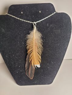 a necklace with a brown feather hanging from it