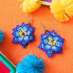 Embrace nature's bloom with our Huichol Beaded Flower Earrings🌺. Expertly handcrafted by one of our partner Huichol artisans, these earrings radiate with vibrant bead patterns, reflecting the beauty of blossoming flowers. They're a must-have for those looking to add a splash of color and cultural charm to their ensemble. Dive into the world of Huichol craftsmanship and let your style flourish！ ◆Symbols in Huichol Jewelry◆ Flowers: They are sacred and used in the healing process and Huichol cele Blue Handmade Spiritual Earrings, Handmade Blue Spiritual Earrings, Handmade Traditional Flower Earrings For Festivals, Bohemian Handmade Flower Earrings, Traditional Handmade Flower Earrings For Festivals, Unique Handmade Blue Flower Earrings, Floral Jewelry For Celebrations, Artisan Flower Earrings, Blue Flower Beaded Earrings For Gift