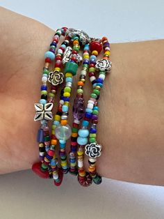 a woman's arm with several bracelets on top of it and two charms attached to the wrist