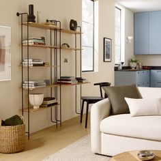 a living room filled with furniture and bookshelves next to a wall mounted lamp