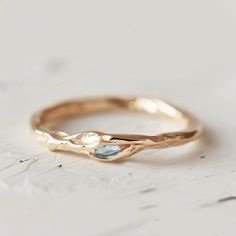 a gold ring with a blue topazte in the center on a white surface