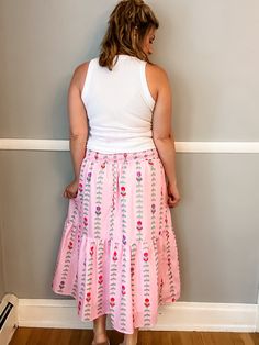 Transform your summer wardrobe with our Pink Tulip Tiered Skirt. This playful and fun piece features a stunning pattern and beautiful colors, perfect for bringing a pop of color to any outfit. With a smocked waist and lining, it not only looks great but also offers a comfortable fit. A must-have for any fashion-forward individual looking to make a statement! Fit is true to size. Emily is 5'8" wearing a medium. Small (0-4) Medium (6-8) Large (10-12) XL (14-16) Spring Vacation Gathered Maxi Skirt, Spring Vacation Maxi Skirt With Gathered Detail, Feminine Tiered Maxi Skirt For Vacation, Summer Flared Maxi Skirt With Elastic Waistband, Summer Tiered Maxi Skirt With Elastic Waistband, Feminine Tiered Maxi Skirt For Beach, Summer Style Gathered Maxi Skirt, Feminine Tiered Skirt For Vacation, Summer Vacation Gathered Maxi Skirt