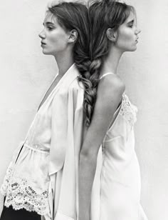 two women standing next to each other with long hair in braids and blouses