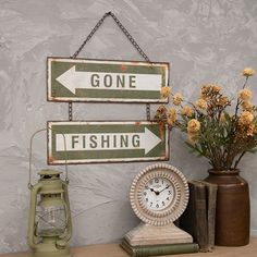 there are two signs that say gone fishing and one has a clock on the table