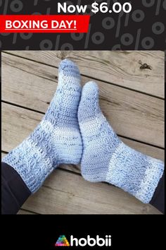 two pairs of blue knitted socks sitting on top of a wooden floor next to each other