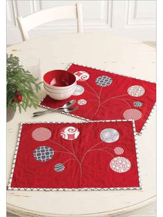 two red placemats sitting on top of a white table