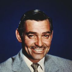 a man in a suit and tie smiling at the camera