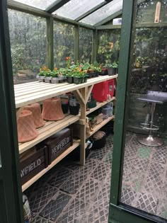 a green house filled with lots of plants and potted plants in it's shelves