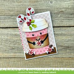 a close up of a card with a cup on it and candy canes in the background