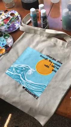 a tote bag sitting on top of a wooden table covered in crafting supplies