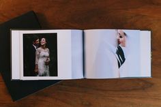 an open photo book on a table with two photos in it and the pages are black