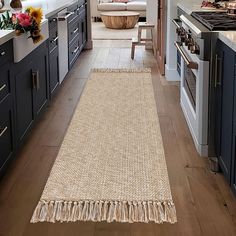 a kitchen with wooden floors and blue cabinets, along with an area rug on the floor