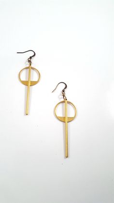 Simple and understated, these modern minimalist earrings are a great go to for everyday wear, to work or a night out. The earrings feature a long golden brass bar that is chin grazing through the middle of a brass geometric circle. These lightweight earrings hang about 2.75 inches in length while the circle hangs 1.5 inches length. The entire look is topped off with a nickel and lead free french ear wire. For more earrings check out our selection here: https://www.etsy.com/shop/DyNaModuo?section Modern Gold Plug Earrings For Everyday, Matte Gold Minimalist Earrings, Matte Gold Minimalist Metal Earrings, Modern Gold Linear Earrings For Gift, Simple Design Modern Gold Earrings, Modern Simple Design Gold Earrings, Modern Gold Earrings With Simple Design, Modern Matte Gold Metal Earrings, Modern Gold Plug Earrings