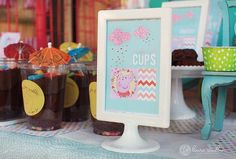 there are many items on the table and in front of the sign that says cupcakes