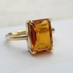 Yellow Gold Topaz Crystal Ring, Yellow Gold Topaz Crystal Ring With Gemstone, Yellow Gold Citrine Crystal Ring With Gemstone, Classic Citrine Crystal Gemstone Ring, Gold Emerald Cut Gemstones For Anniversary, Yellow Gold Rings With Rectangular Gemstone, Gold Emerald Cut Gemstones For Wedding, Emerald Cut Yellow Gold Crystal Ring, Gold Emerald Cut Gemstones With Accent Stones