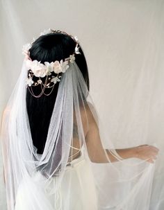 a woman wearing a veil with flowers on it