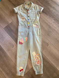 Up cycled jumpsuit with vintage fabric patches.  Overdyed for a vintage feel.  Vintage buttons. denim has stretch  waist flat measurement 15"  rise 11 1/2" inseam 27" armpit to armpit flat measurement 18" Cotton Overalls With Pockets For Festival, Fitted Light Wash Denim Jumpsuit With Buttons, Cotton Denim Blue Jumpsuits And Rompers With Button Closure, Fitted Medium Wash Overalls With Buttons, Retro Cotton Jumpsuits And Rompers With Pockets, Vintage Cotton Denim Jumpsuit For Summer, Retro Denim Overalls Jumpsuits And Rompers, Cotton Denim Jumpsuit With Button Closure, Upcycled Fitted Casual Jeans