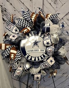 a football wreath is hanging on the side of a wooden wall with cowboys decorations around it