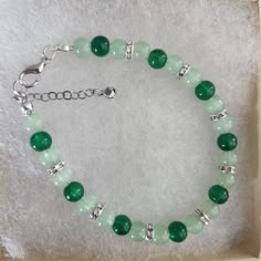 Green Round Bead Bracelet ,Rhinestone Spacers,Glass Bead Bracelet, Green Color,  Green Glass Bead Bracelet, Rhinestones, Silver Lobster Clasp Approximately 7 inches, make sure this will fit your wrist. Beads used are 6 mm in diameter  Rhinestone Spacers All my bracelets are handmade. Please note -  I do my very best to give you accurate measurements and descriptions All my jewelry is delivered in a gift box and beautiful organza gift bag, perfect for keeping your jewelry safe, or ready to give if it is a gift! No refunds or exchanges * see more brackets at https://decowrist.etsy.com/ Cheap Green Bracelets For Holiday, Crystal Gemstone Beaded Bracelets, Silver Crystal Bracelets With Beads, Silver Beaded Bracelets With Stones, Crystal Beaded Charm Bracelet With Round Beads, Green Beaded Bracelets With Stones As Gift, Green Beaded Bracelets For Jewelry Making, Green Beaded Stone Bracelets As Gift, 8mm Crystal Bead Bracelet