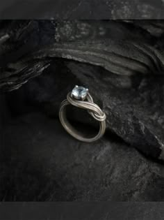 an engagement ring sitting on top of a rock