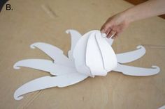 someone is making a paper crab on the floor