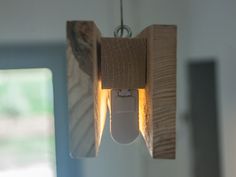 a light fixture hanging from the ceiling in a room with white walls and wood paneling