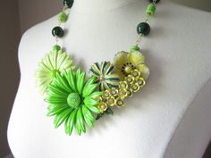 This entire necklace was designed around the spray of tiny yellow enamel flowers that have rhinestone centers and green leaves.  Previously a vintage brooch, I combined it with four other vintage enamel flower brooches in complementary shades of lemon yellow, lime green, and grass green (all backs removed).  This beautiful bouquet is securely mounted upon a clear lucite necklace base and measures approximately 6 inches across by 4 inches top to bottom (at its widest and tallest points).   I've a Green Flower Pendant Jewelry For Wedding, Green Flower Pendant Necklace For Wedding, Green Enamel Jewelry For Wedding, Green Enamel Wedding Jewelry, Green Flower-shaped Enamel Jewelry, Enamel Flowers, Green Gardens, Blue Words, Yellow Lime