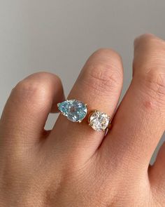 a woman's hand with two different colored diamonds on top of her finger,