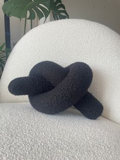 a black stuffed animal sitting on top of a white couch