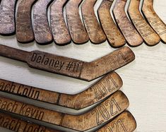 a bunch of wooden name tags on a white table with some type of wood in the middle