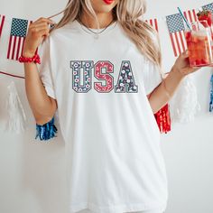 Celebrate Independence Day with Ease on Our 4th of July Cotton T-Shirt! Are you struggling to find the perfect outfit for your 4th of July celebration this year? Look no further! Our high-quality 4th of July themed t-shirt provides a quick and easy wardrobe solution for women and families.  Featuring soft cotton fabric and a quality print, our t-shirt offers comfort and style all in one. Say goodbye to the stress and time-consuming process of searching for the ideal outfit - our themed t-shirt h Patriotic Crew Neck T-shirt For Spring, White American Style Tops For Memorial Day, American Style Flag Print Top For 4th Of July, Patriotic Pre-shrunk Shirt For 4th Of July, Patriotic Flag Print Shirt For 4th Of July, Patriotic American Flag Print Tops For 4th Of July, Patriotic Shirt With Flag Print For 4th Of July, Patriotic Crew Neck Top For Memorial Day, Patriotic Shirt With American Flag Print For Independence Day