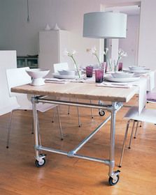 a dining room table with white chairs and a lamp on top of the wooden floor