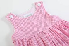 This dress is egg-stra cute! 🐰🌸 With its pink gingham pattern, bunny applique, and elegant white trim, your little one will be the star of any Easter celebration. The tie bow back adds a fun twist to this adorable and joyful dress! 🐇🎀 Cute Pink Dresses With Buttons, Cute Pink Dress With Buttons, Sweet Gingham Dress For Spring, Sweet Spring Gingham Dress, Pink Preppy Cotton Dress, Sweet Gingham Cotton Dress, Sweet Gingham Dress With Ruffles, Gingham Dresses With Buttons For Picnic, Gingham Dress With Buttons For Picnic