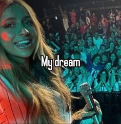 a woman holding a microphone in front of an audience with the words, my dream