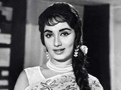 an old black and white photo of a woman with long hair in a ponytail wearing pearls