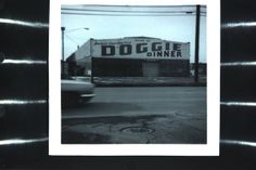 a black and white photo of a dogie diner on the side of a road