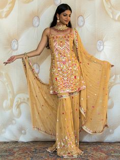 Introducing the Sakshi Sharara - the epitome of elegance and style. This exquisite women's suit is perfect for all your special occasions and ceremonies. With its fusion of Indian and Western elements, it is a true reflection of modern fashion. Key Features: Color: Five Star Yellow Designed for women Perfect for events and ceremonies Indo-Western fusion Beautifully crafted High-quality fabric Make a statement with the Sakshi Sharara. Its vibrant Five Star Yellow color will make you stand out fro Formal Fitted Salwar Kameez With Sheer Dupatta, Elegant Fitted Sharara For Reception, Festive Yellow Formal Dupatta, Fitted Palazzo Set With Traditional Drape For Formal Occasions, Elegant Yellow Salwar Kameez For Party, Formal Gold Sets With Mirror Work, Elegant Salwar Kameez With Dori Work For Wedding, Elegant Gota Work Palazzo Set For Reception, Formal Fitted Sharara With Traditional Drape