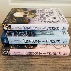 three books stacked on top of each other in front of a door with the words kingdom of the wicker