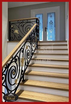 an iron stair railing with wood handrails and glass panels on the door way