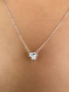 This Beautiful timeless floating diamond pendant is set with a lab-grown heart-shaped diamond in 14k solid gold. It will be the classic perfect gift for any woman in your life--whether she's your wife, girlfriend, fiancée, or bride. The photos show a 0.75ct heart-shaped lab-grown diamond. All of our diamonds are high-quality D color, VS1 clarity. Each diamond is securely set in a Prong setting, radiating sophistication with every glance. Every diamond is expertly positioned to reflect maximum light and brilliance that tells your forever love story. The pendant and chain are made of 14k solid gold and feature a spring clasp. Our collection offers a variety of sizes and carat weights to suit diverse preferences. For the heart diamond pendant Choose from diamonds ranging from 0.5 carats measu White Gold Heart Pendant Necklace With Single Diamond, Classic Sterling Silver Heart Diamond Necklace, Classic Diamond Necklace With Heart Charm For Wedding, White Gold Heart Pendant Diamond Necklace, Classic Diamond White Necklace With Heart Charm, Classic Wedding Diamond Necklace With Heart Charm, Classic Single Diamond Heart Necklace Gift, Classic Diamond Cut Heart Necklace For Anniversary, Classic Diamond Necklace With Heart Charm As Gift