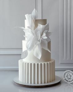 a three tiered white wedding cake on a plate