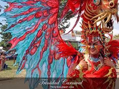 a woman in red and blue costume standing next to a large dragon headdress