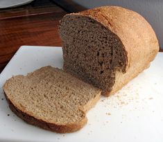 a loaf of brown bread sitting on top of a white cutting board