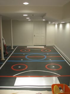 an indoor basketball court is being painted with red, white and blue circles on it