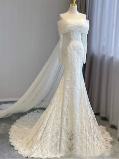 a white wedding dress on display in front of a window