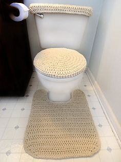 a white toilet sitting in a bathroom next to a wooden cabinet